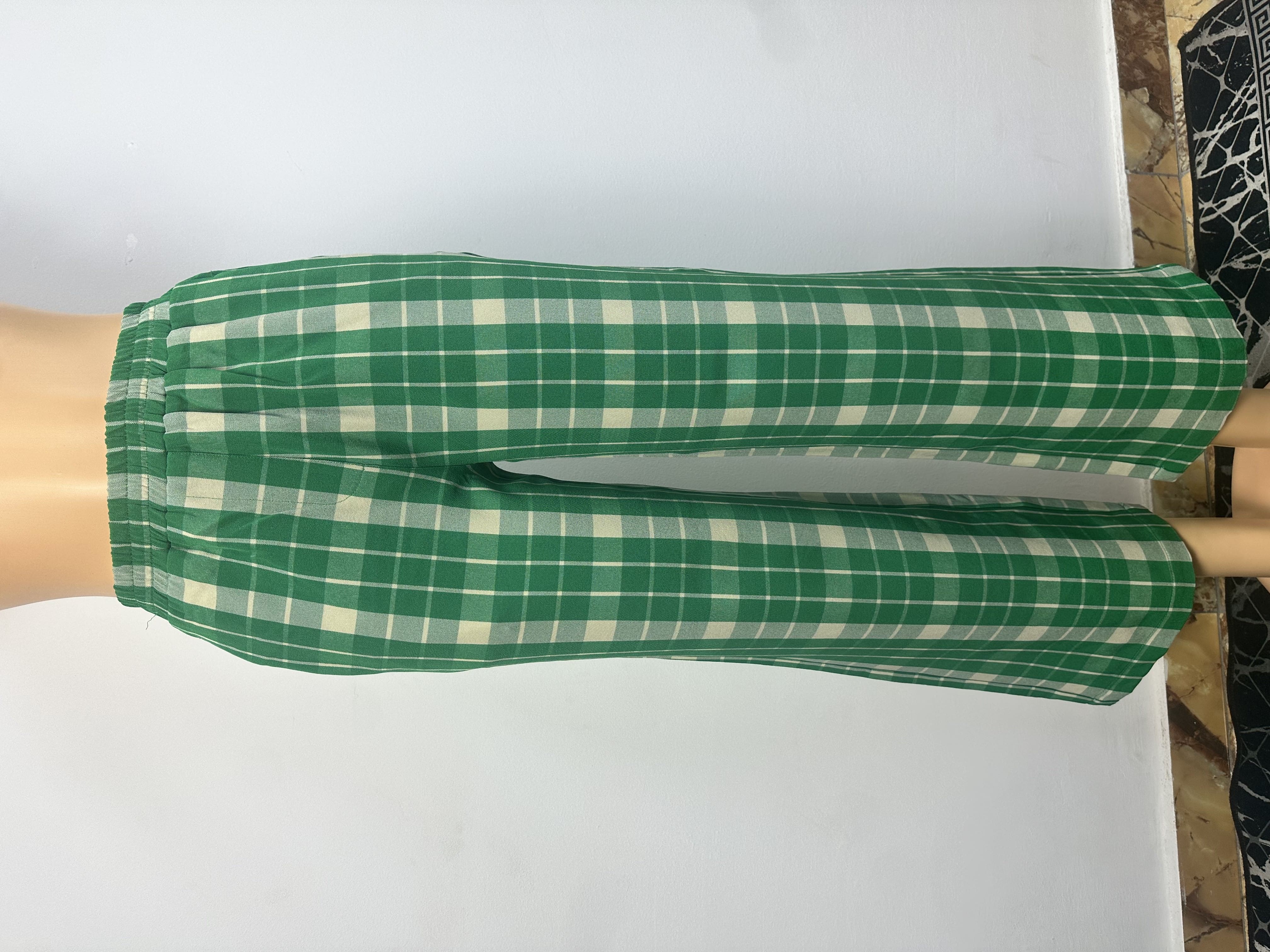 Pantalon vert, à carreaux blancs, il est doté d'une ceinture élastique et ne présente ni boutons ni cordons de serrage.