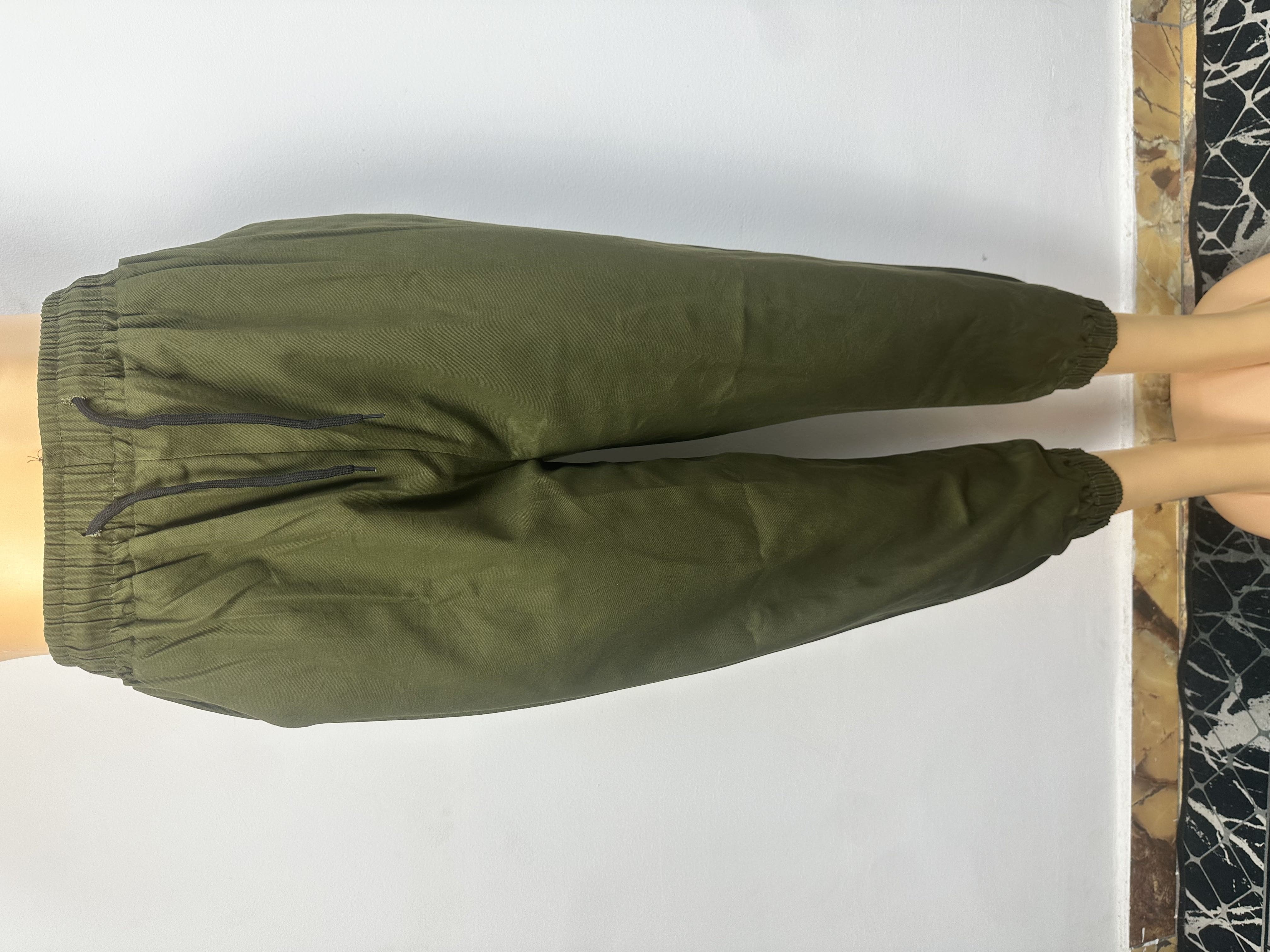 Pantalon vert olive foncé uni avec une taille élastique et un cordon de serrage vert.