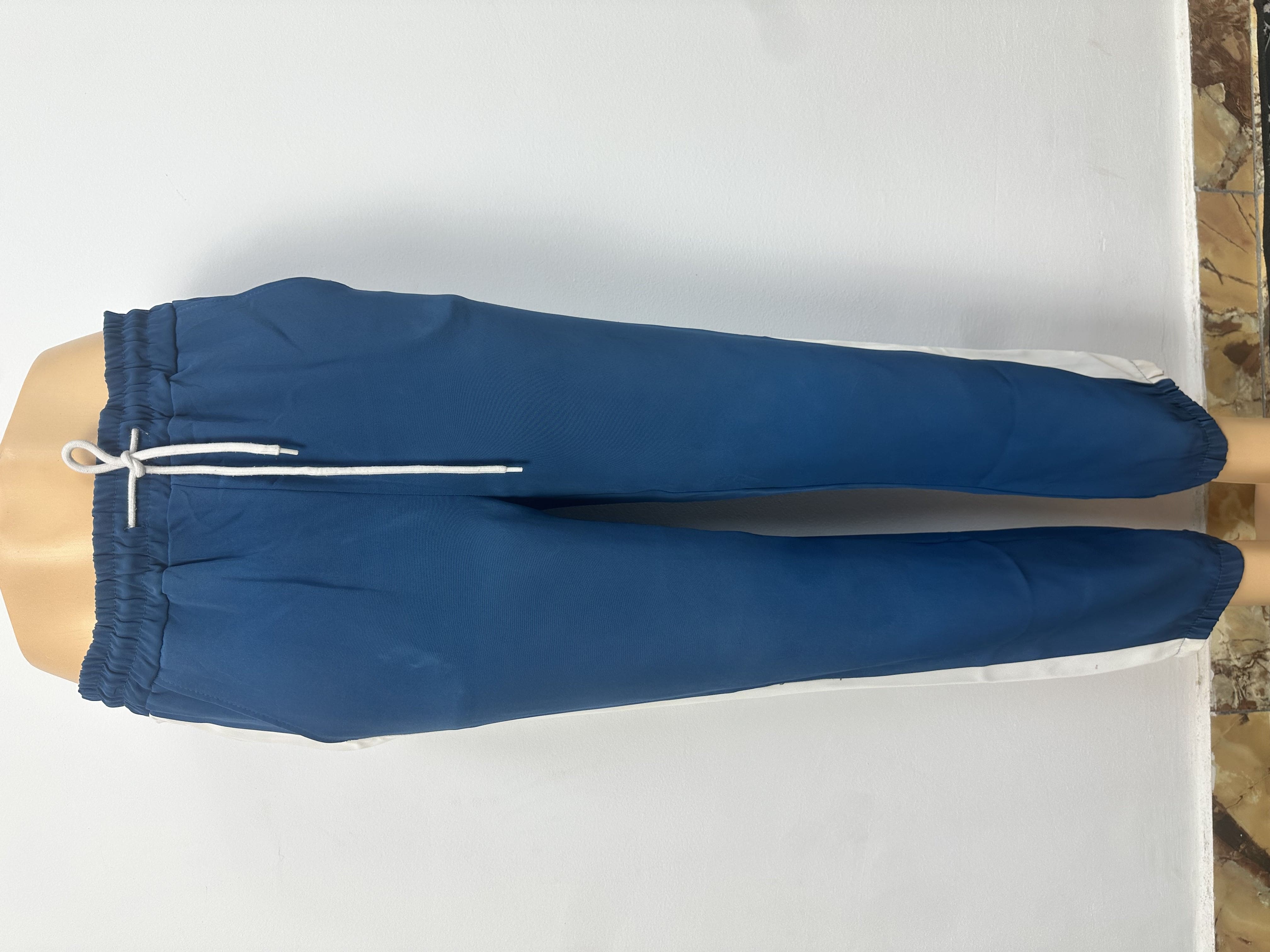 Pantalon bleu foncé avec des bandes latérales blanches, avec une ceinture élastique et un cordon de serrage blanc.