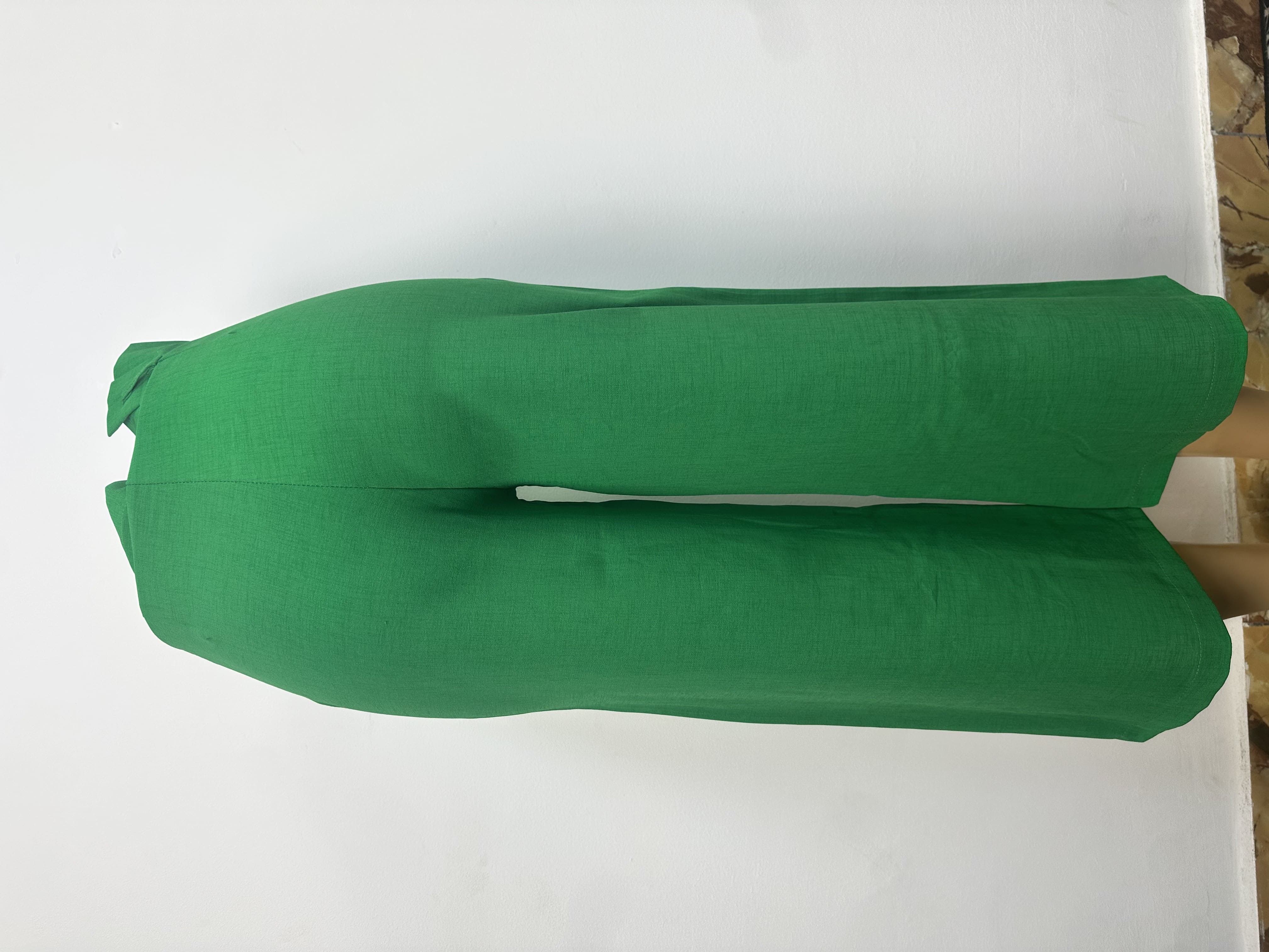 Pantalon vert vif uni, avec ceinture ajustée, passants et fermeture boutonnée. Coupe droite et courte au-dessus de la cheville.